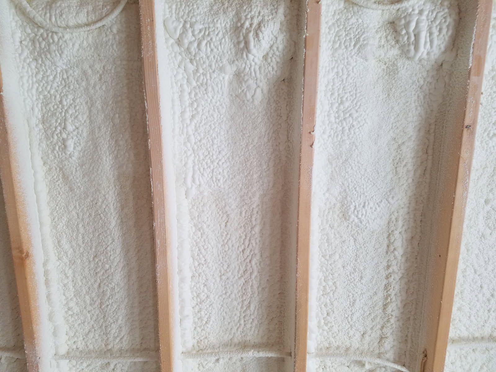 A wall with a lot of foam on it and wooden beams.