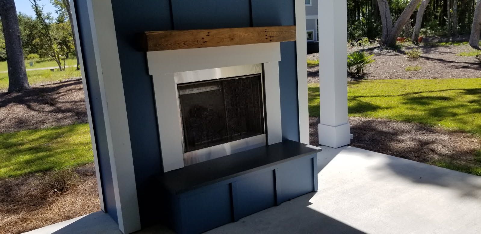 There is a fireplace in the backyard of a house.