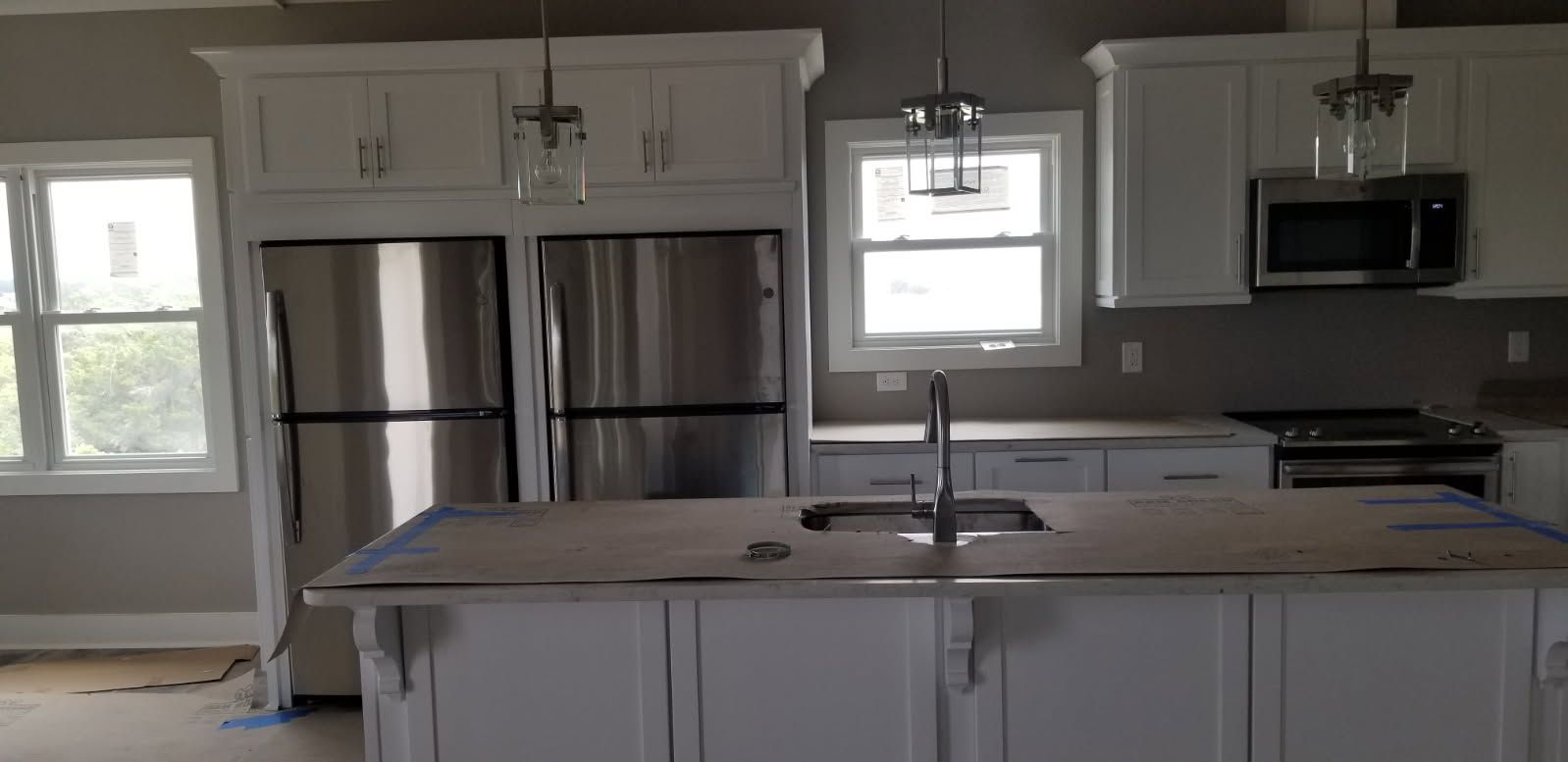 A kitchen with white cabinets and stainless steel appliances.