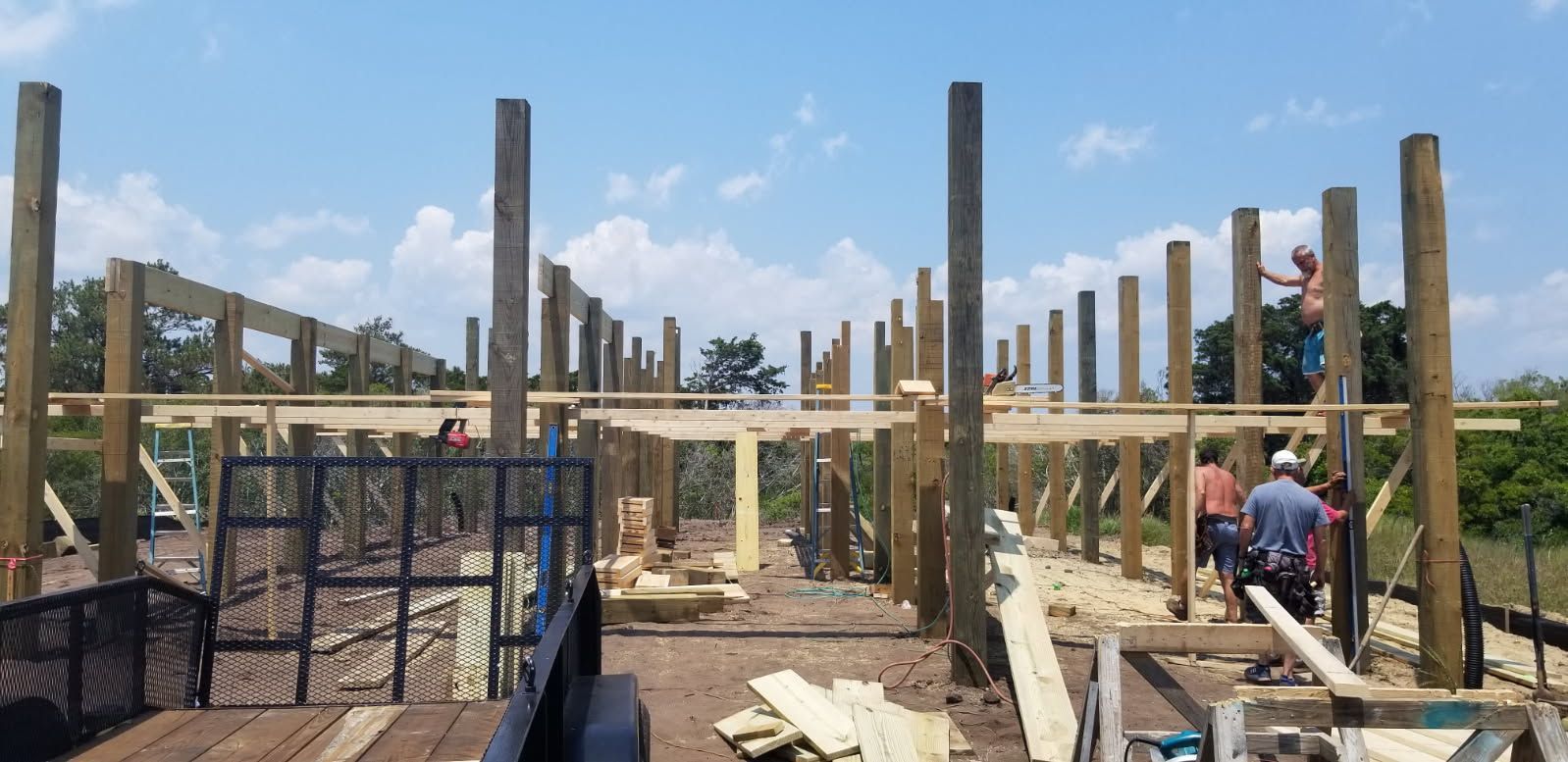 A group of people are working on a wooden structure.