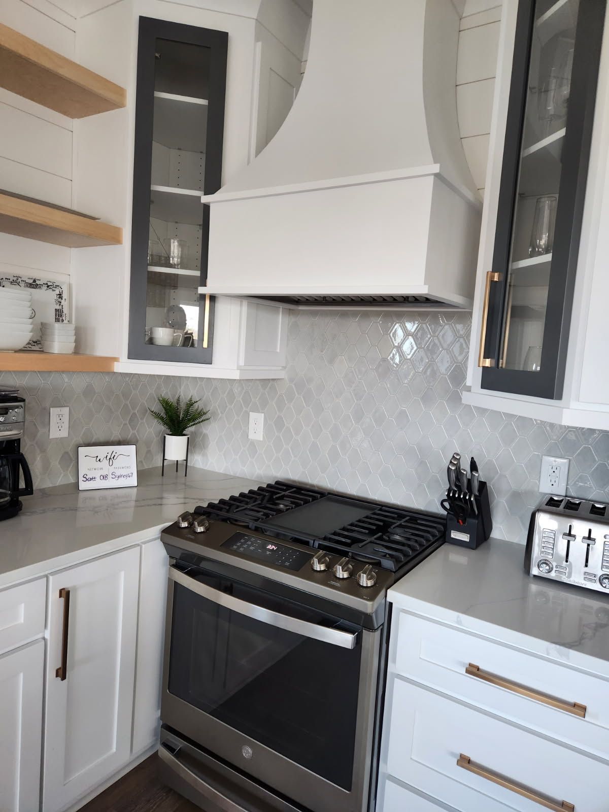 A kitchen with a stove top oven and white cabinets