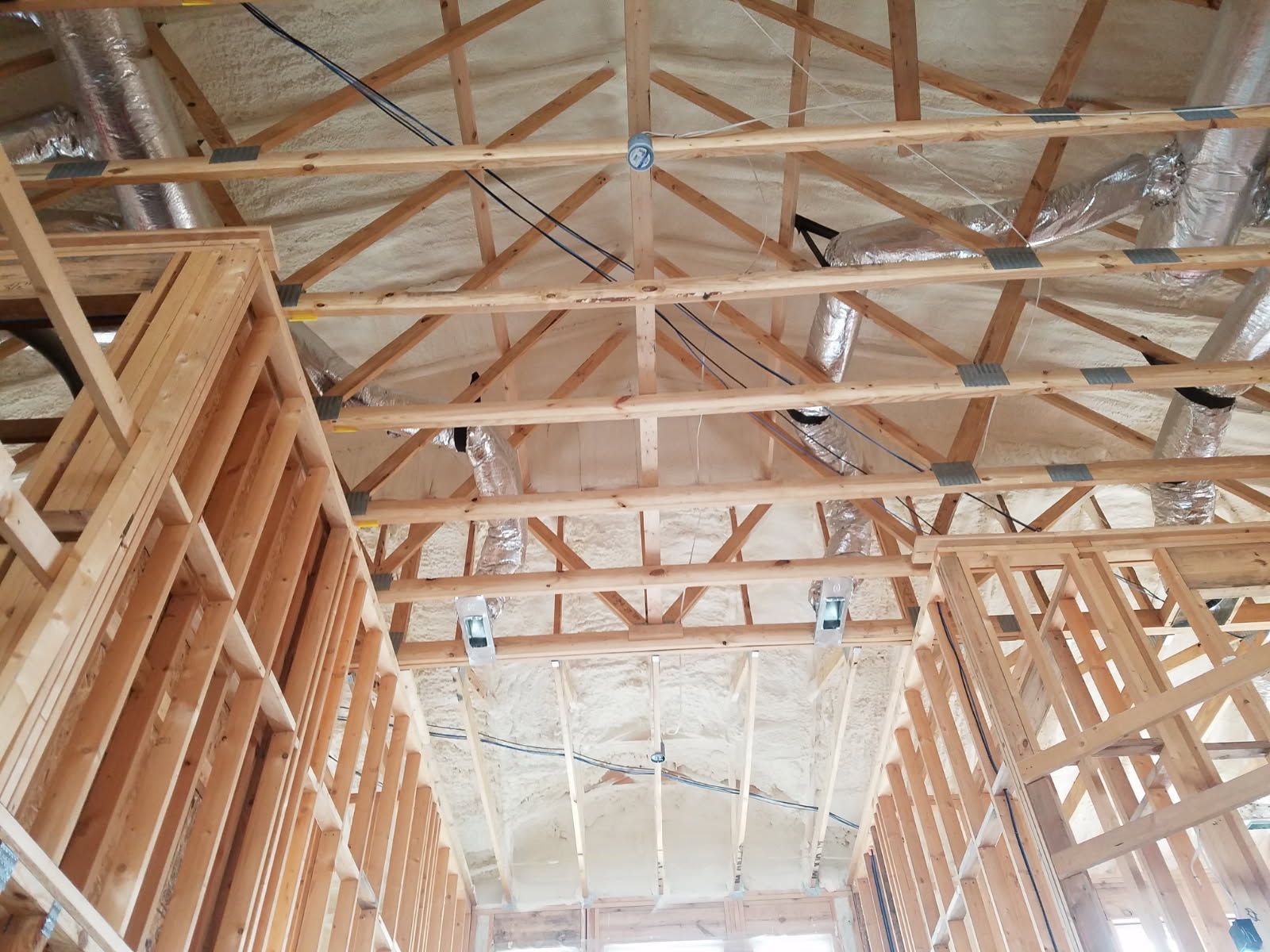 The ceiling of a building under construction with a lot of wooden beams.