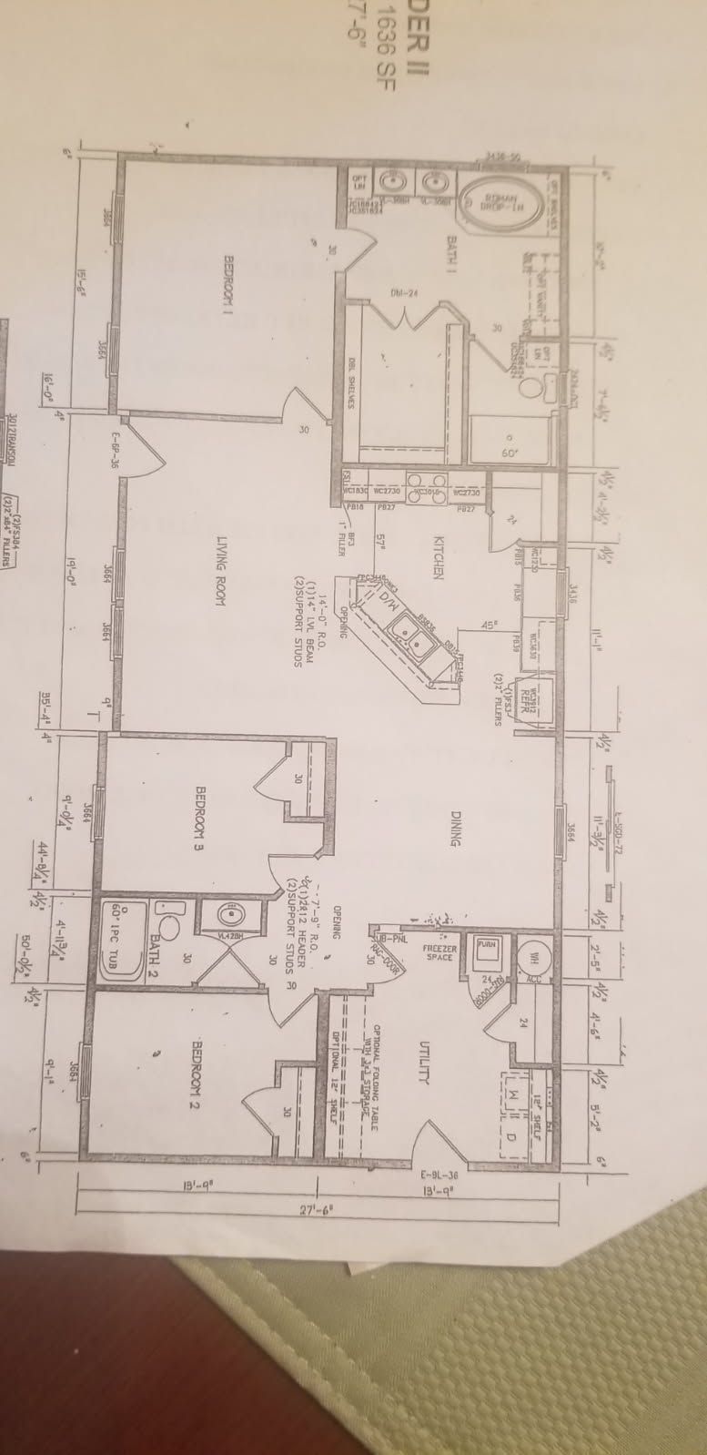 A black and white floor plan of a house on a table.