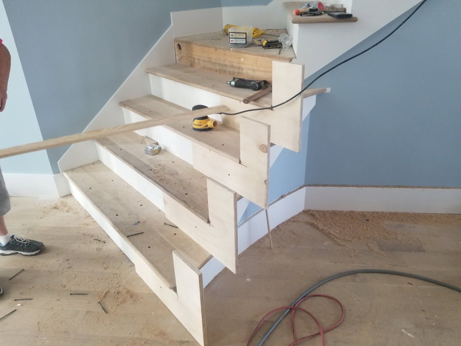 A wooden staircase is being built in a room