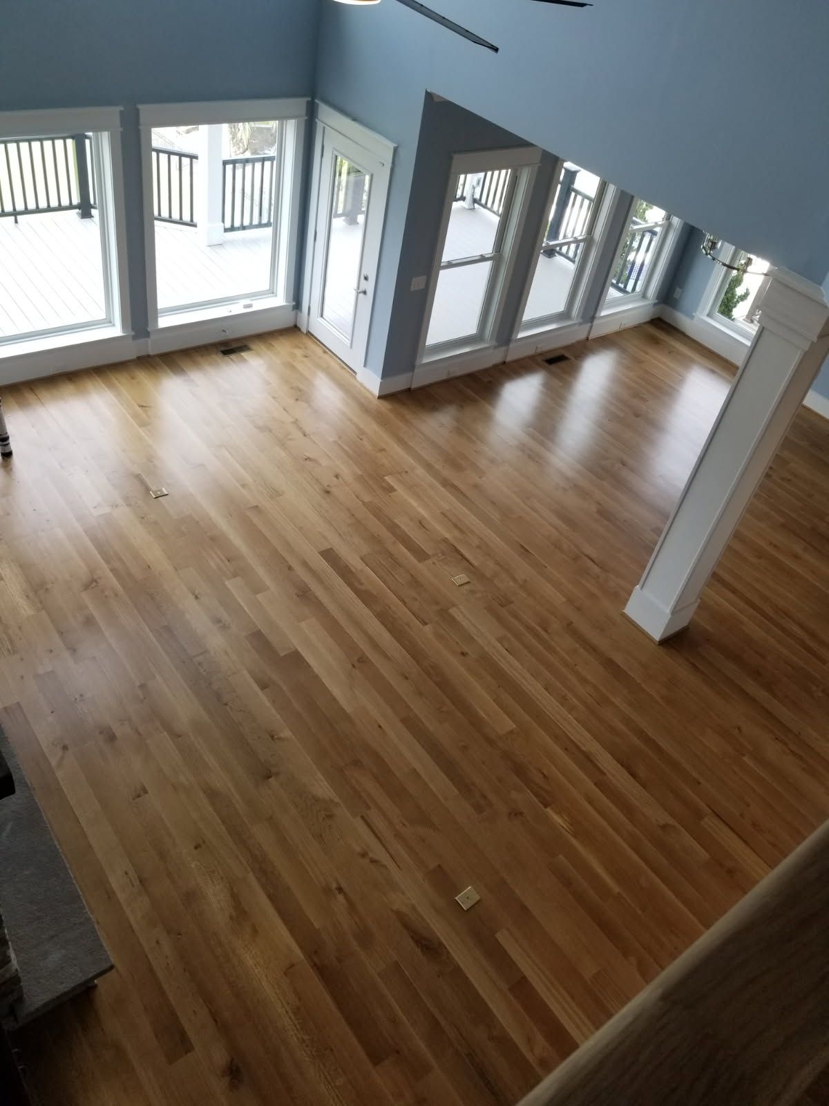 A living room with hardwood floors and lots of windows