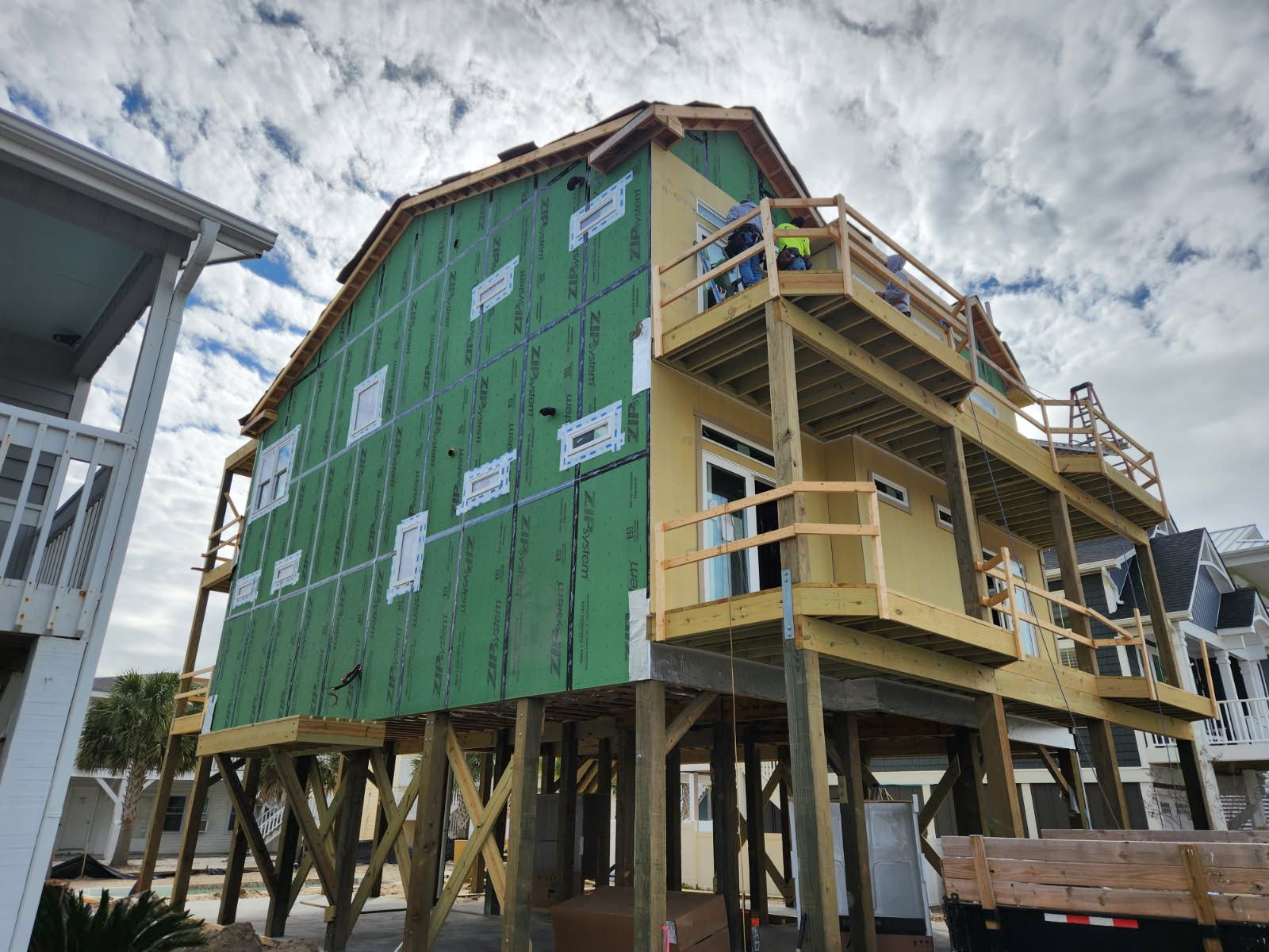 A house is being built on stilts on a cloudy day.