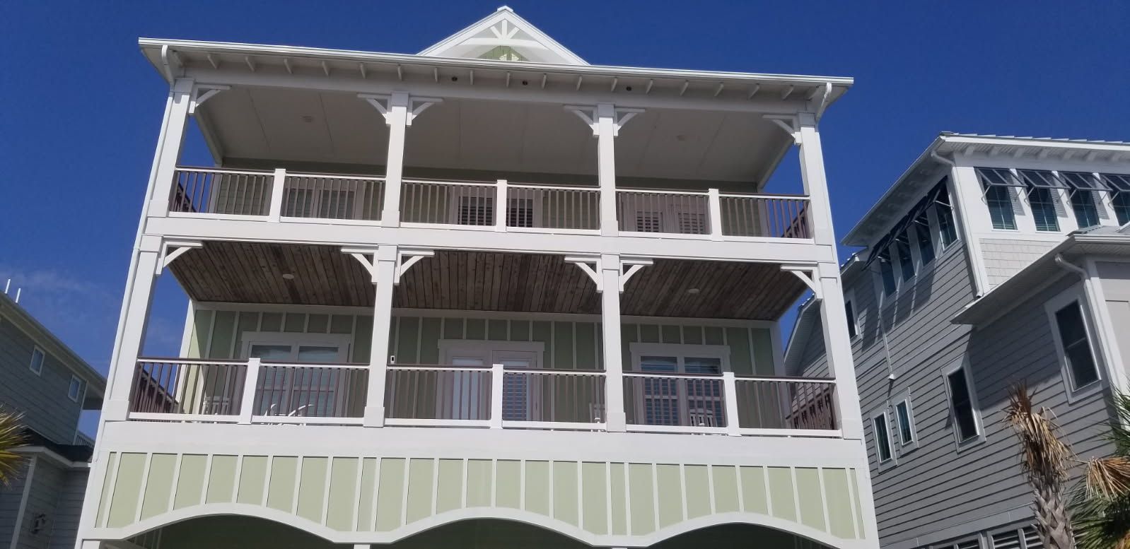 A large house with a lot of balconies and a blue sky in the background