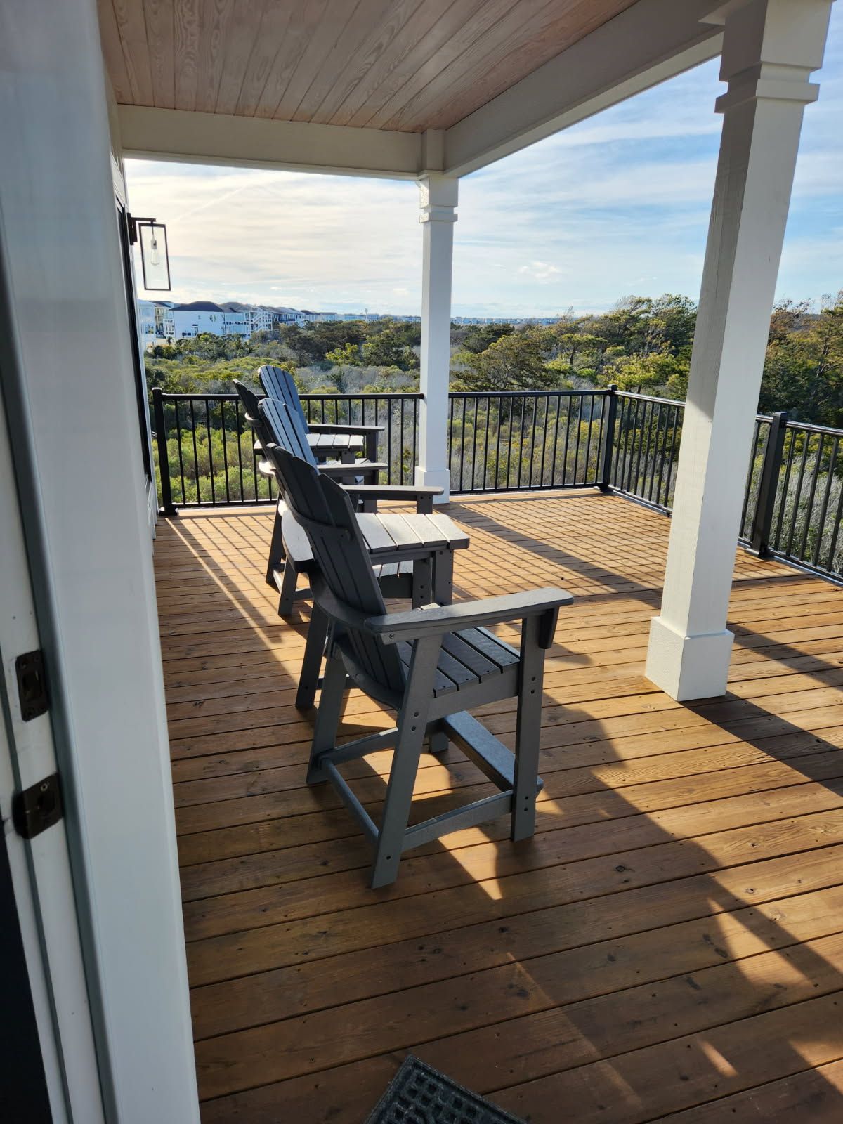 A wooden deck with chairs and a table on it.