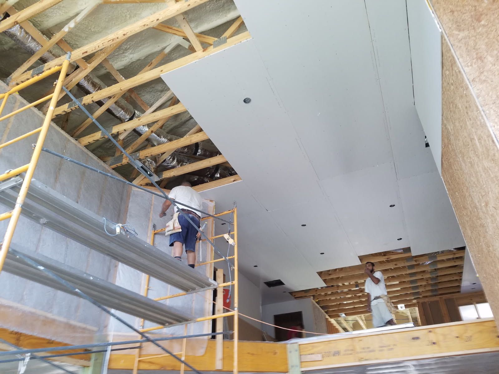 A man is standing on a scaffolding in a building under construction