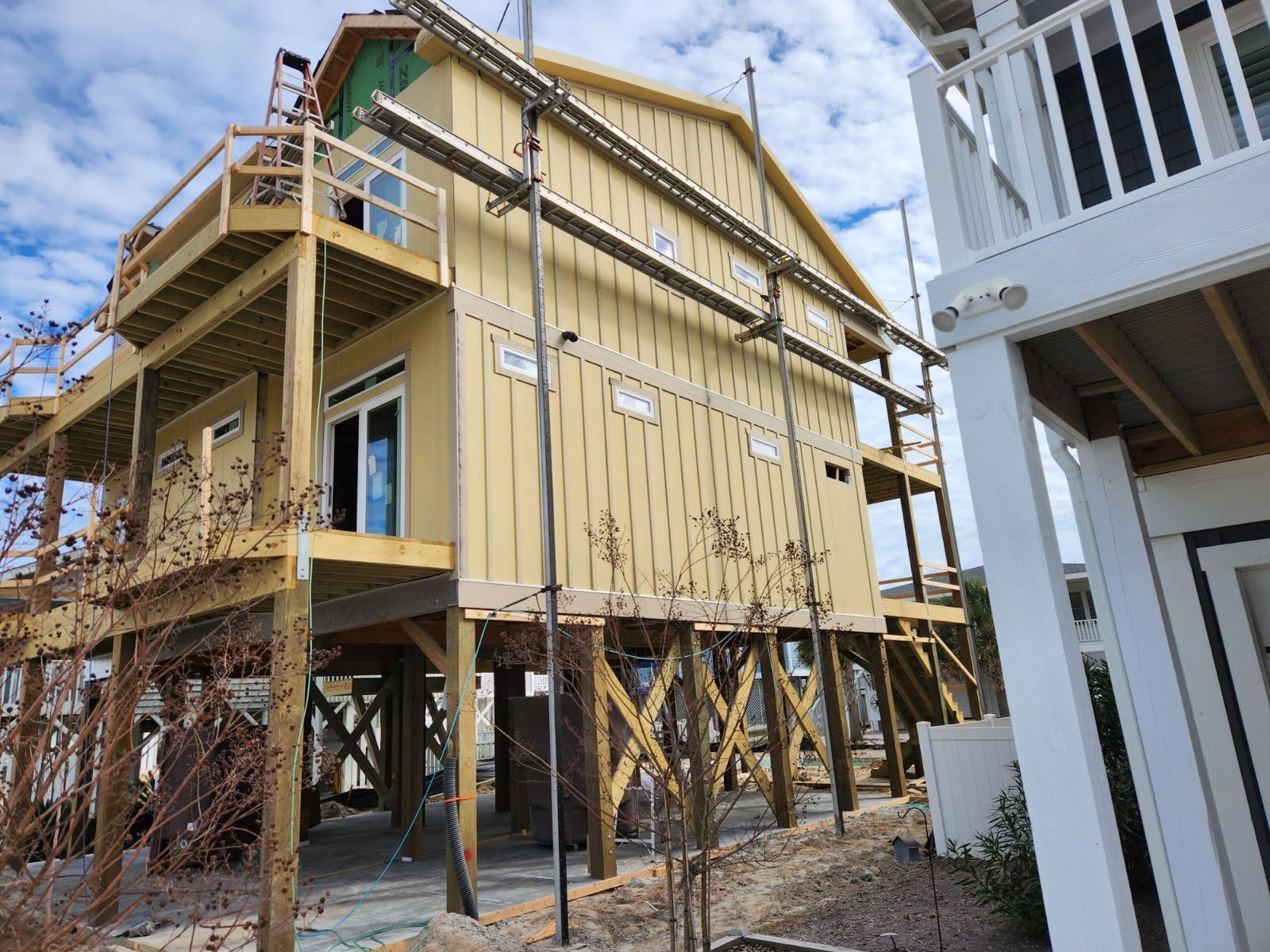 A house is being built on stilts with scaffolding around it.