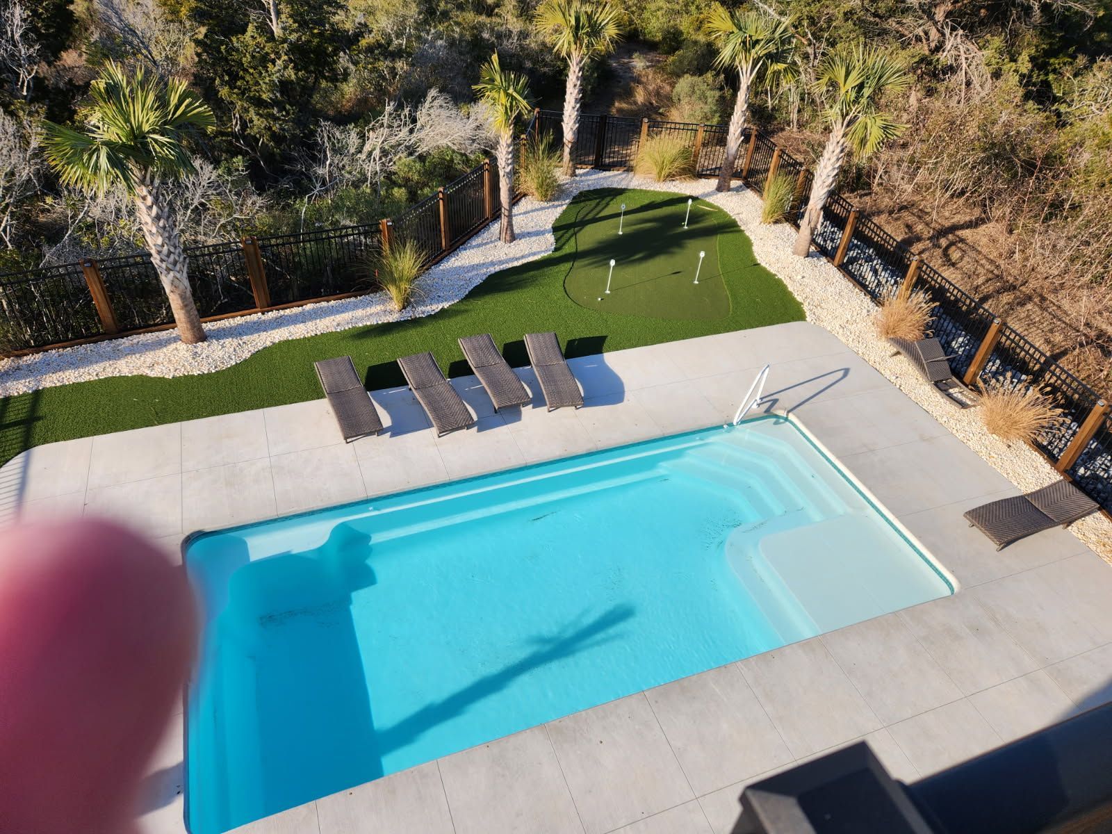 An aerial view of a large swimming pool with chairs around it