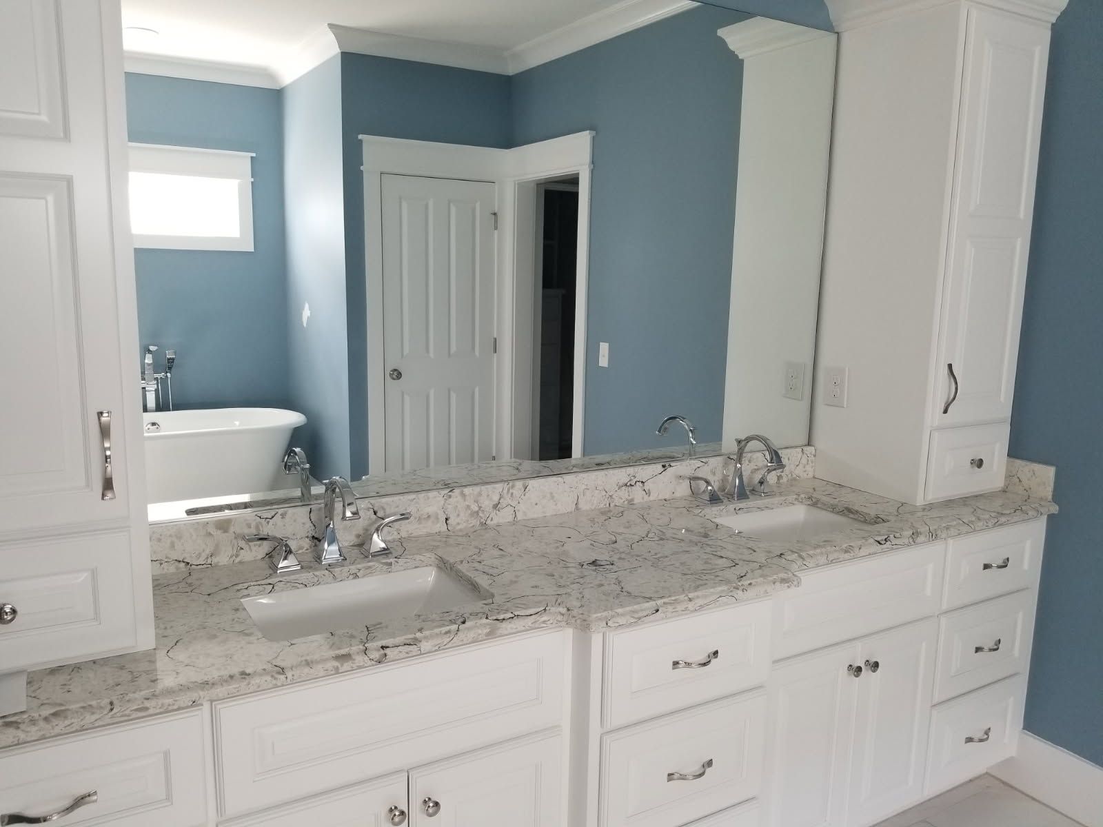 A bathroom with two sinks and a large mirror.
