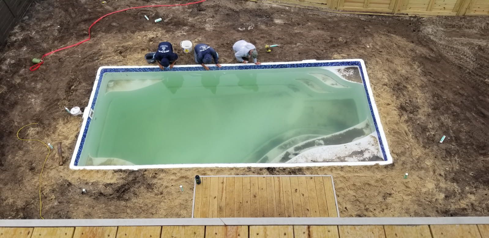 An aerial view of a swimming pool being built in a backyard.