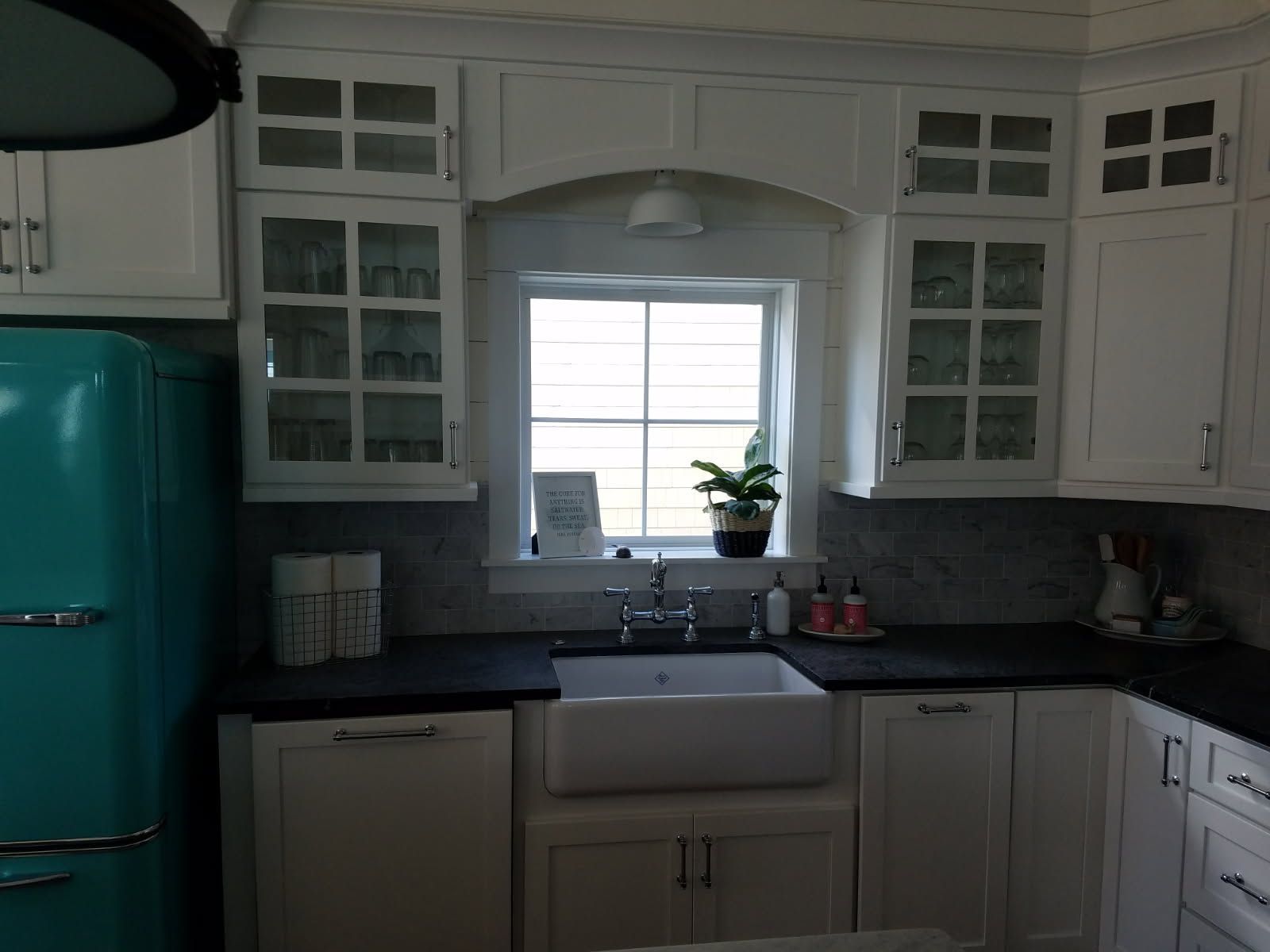 A kitchen with white cabinets and a blue refrigerator