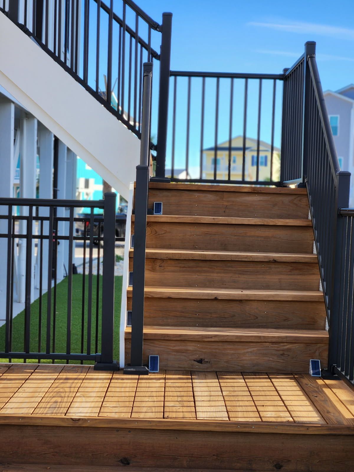 A set of wooden stairs with a metal railing