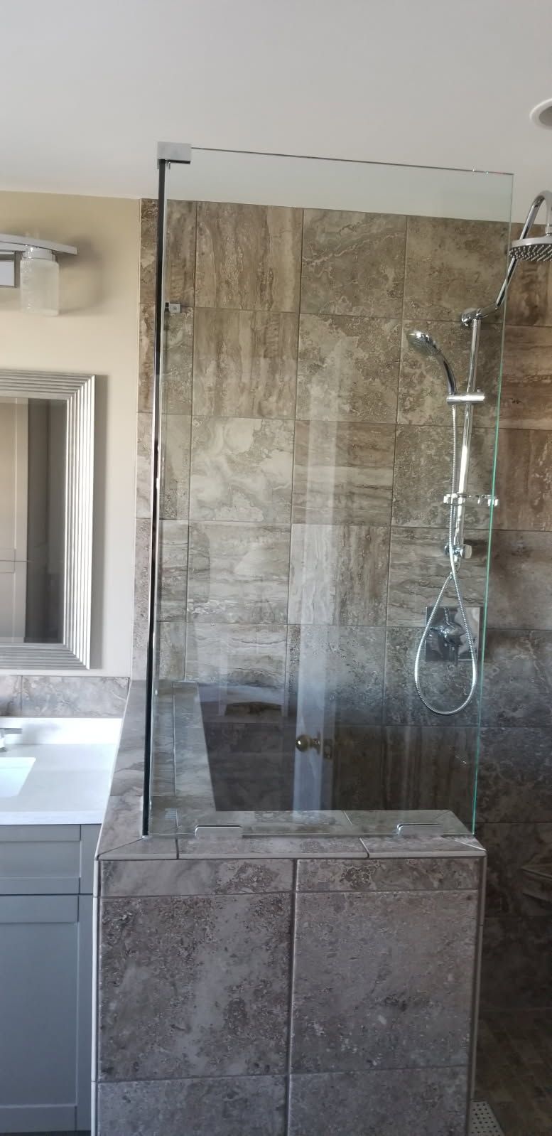 A bathroom with a walk in shower and a sink.