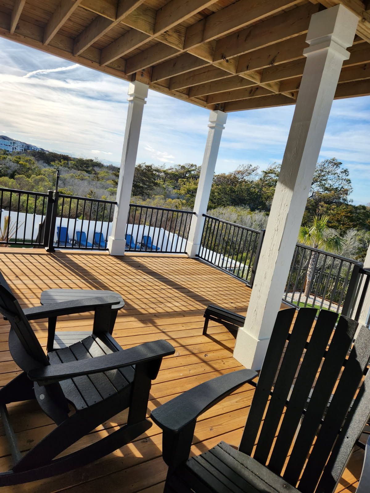 There are two chairs on the deck with a view of the mountains.