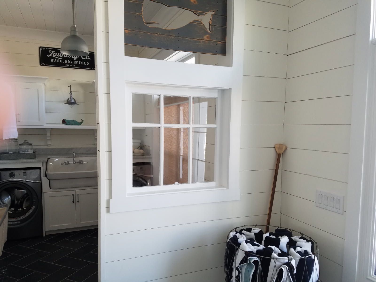 A laundry room with a washing machine and a window