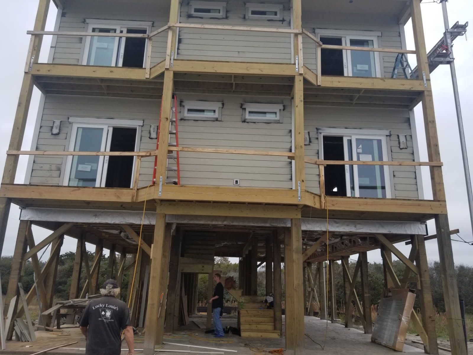 A man is standing in front of a house under construction