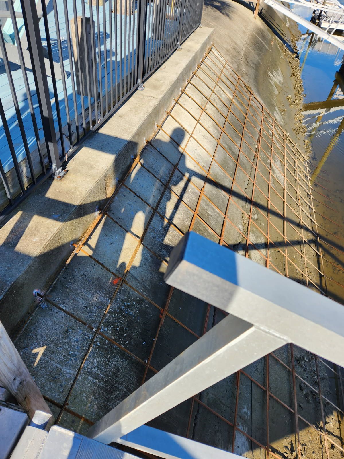 A shadow of a person is cast on the side of a bridge.