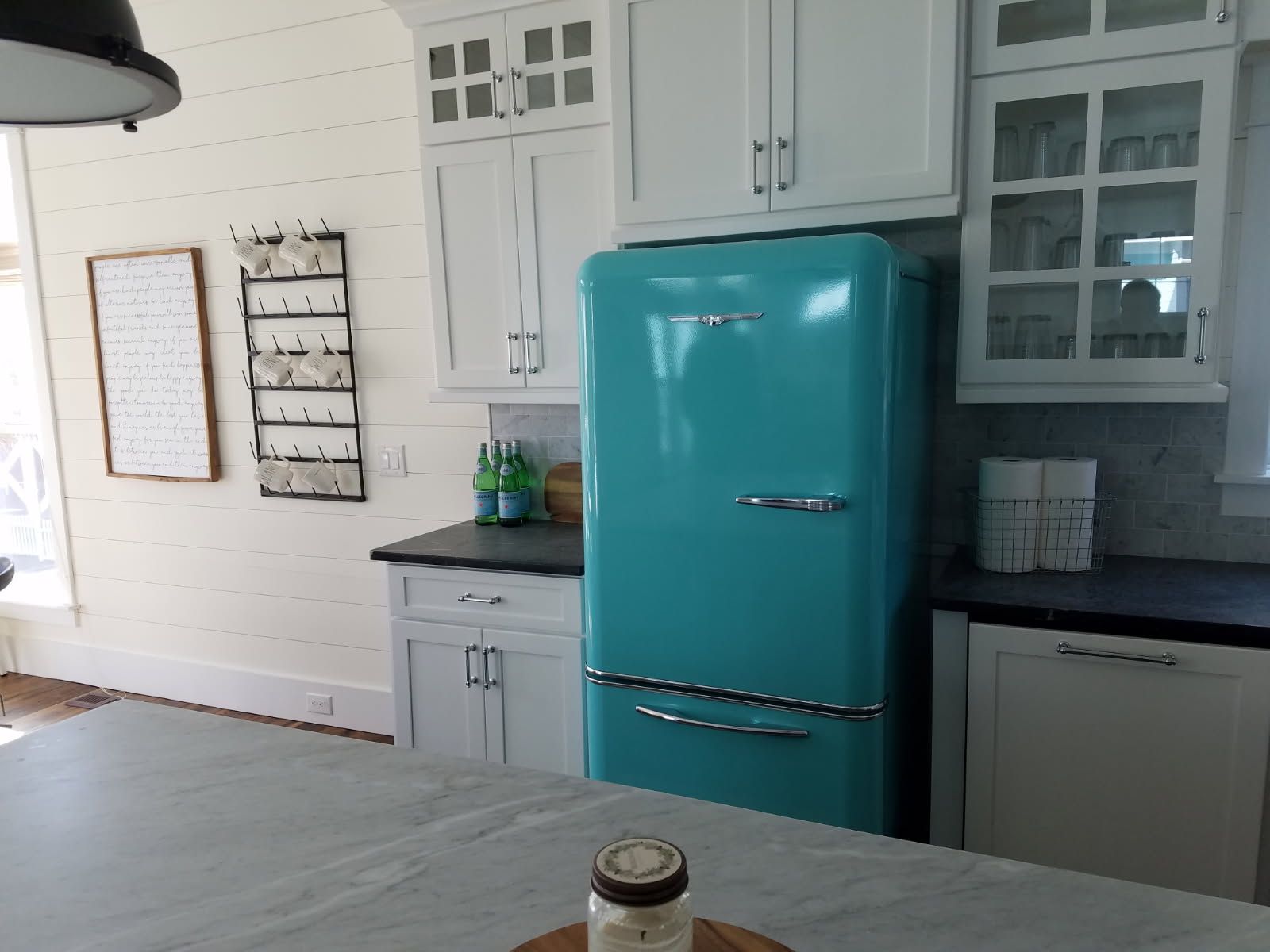 A kitchen with a blue refrigerator and white cabinets