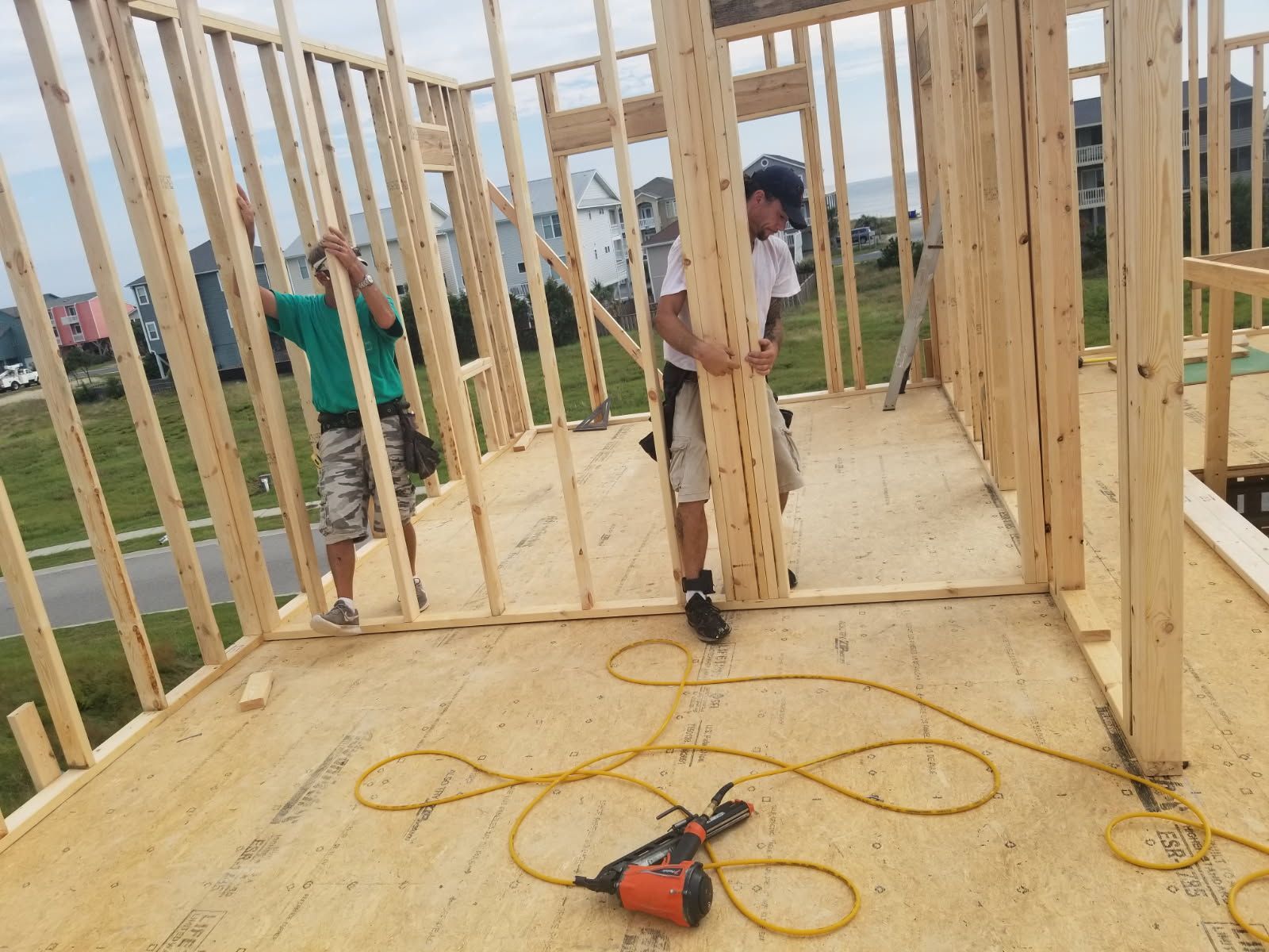 Two men are working on a wooden house.