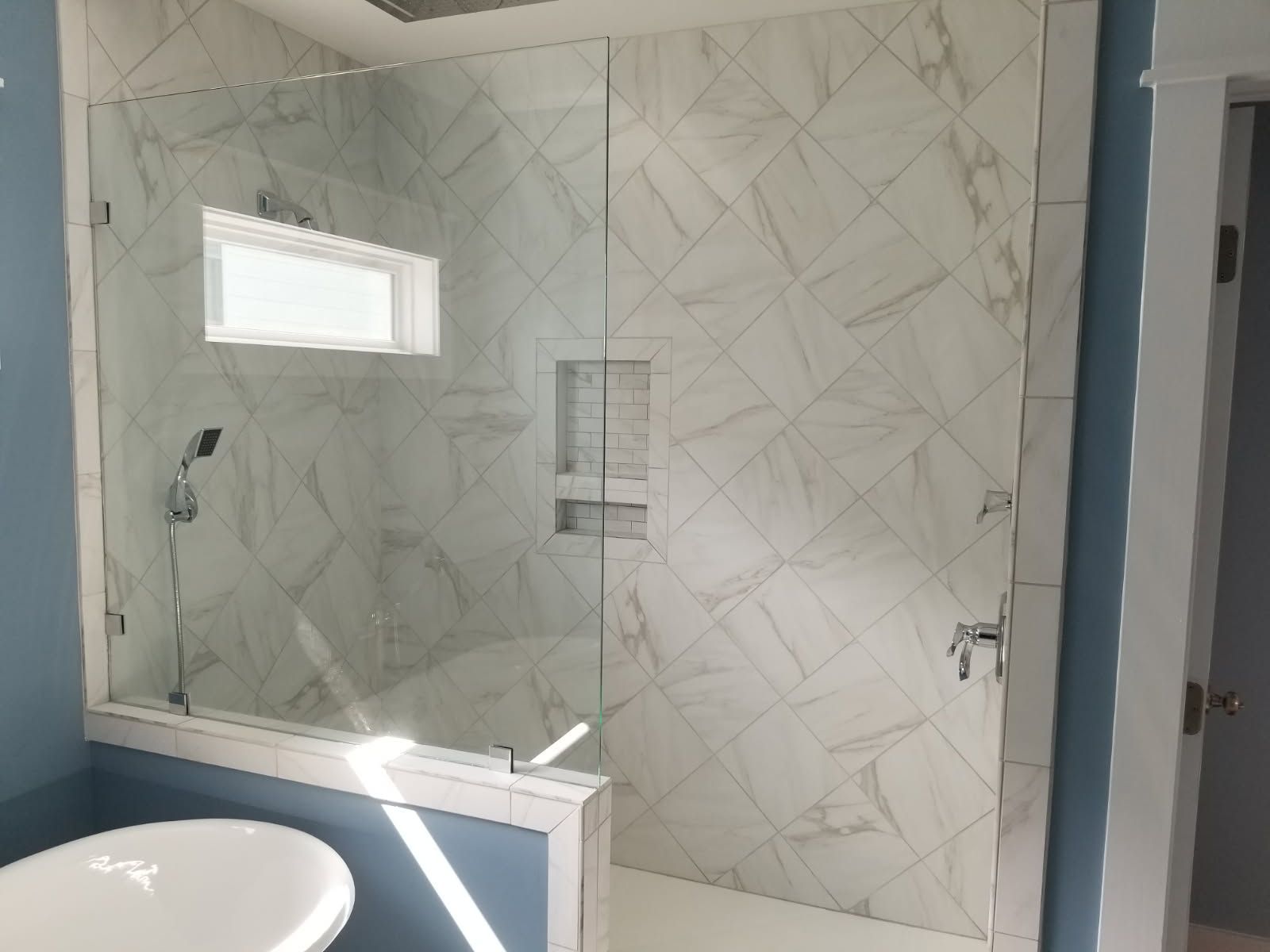 A bathroom with a walk in shower and a bathtub.