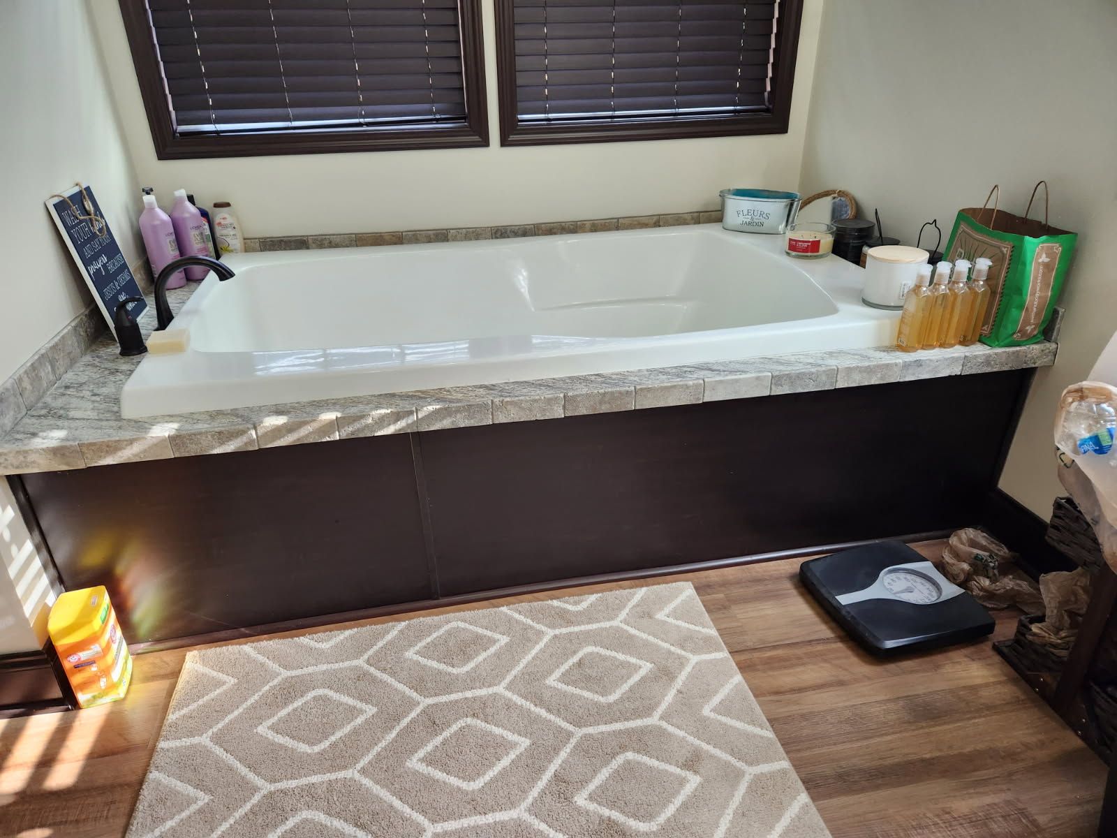 A bathroom with a jacuzzi tub and a scale on the floor.