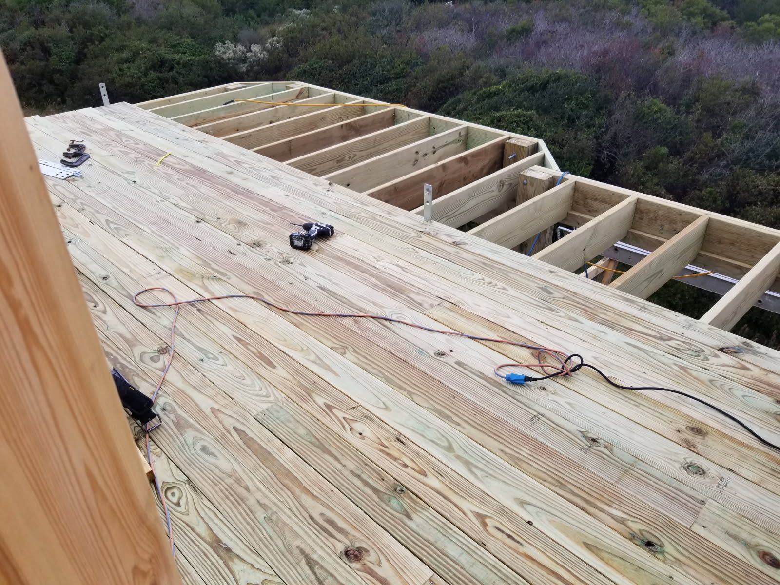 A wooden deck is being built on top of a house.