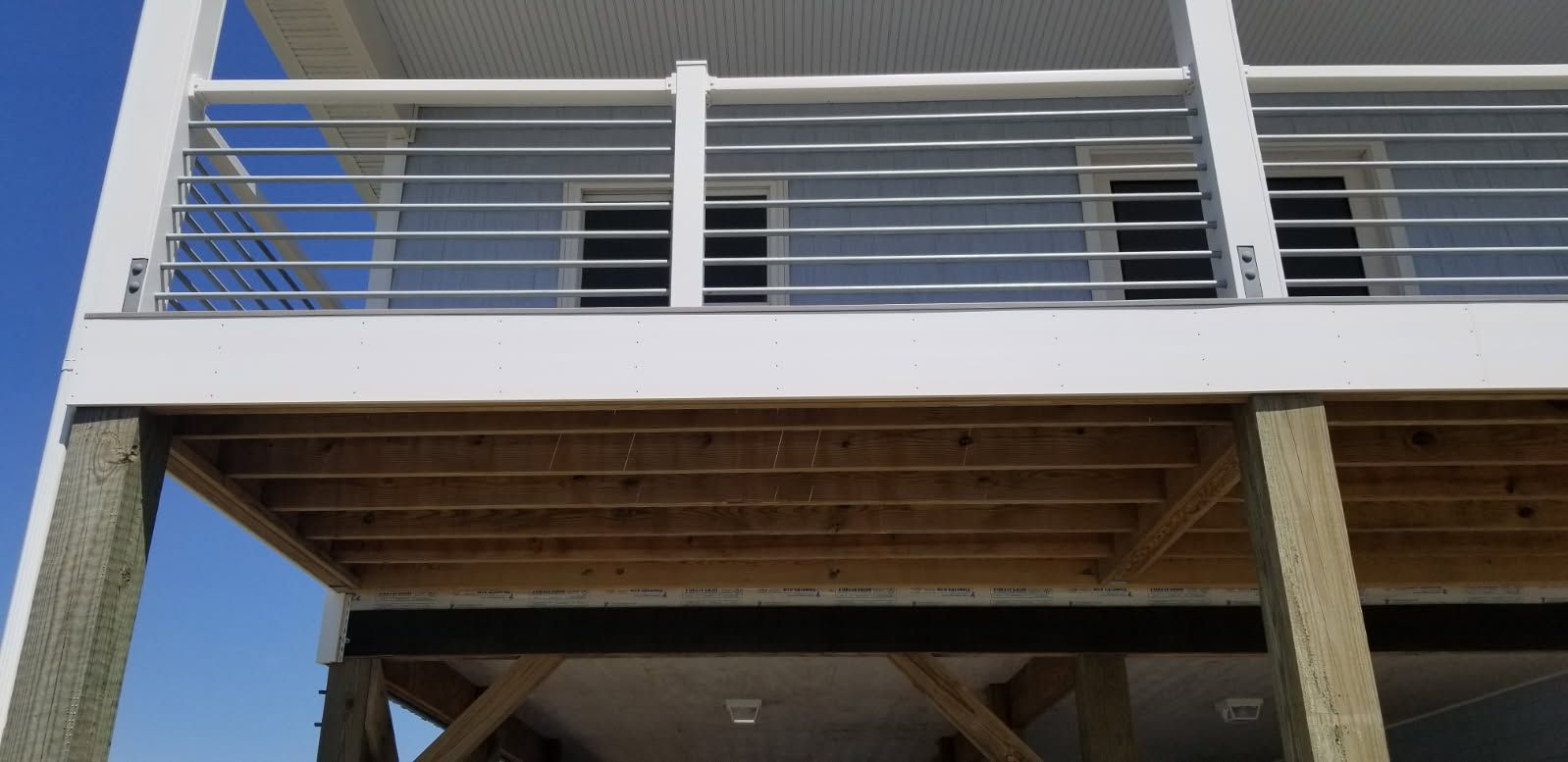 A house with a wooden deck and a stainless steel railing.