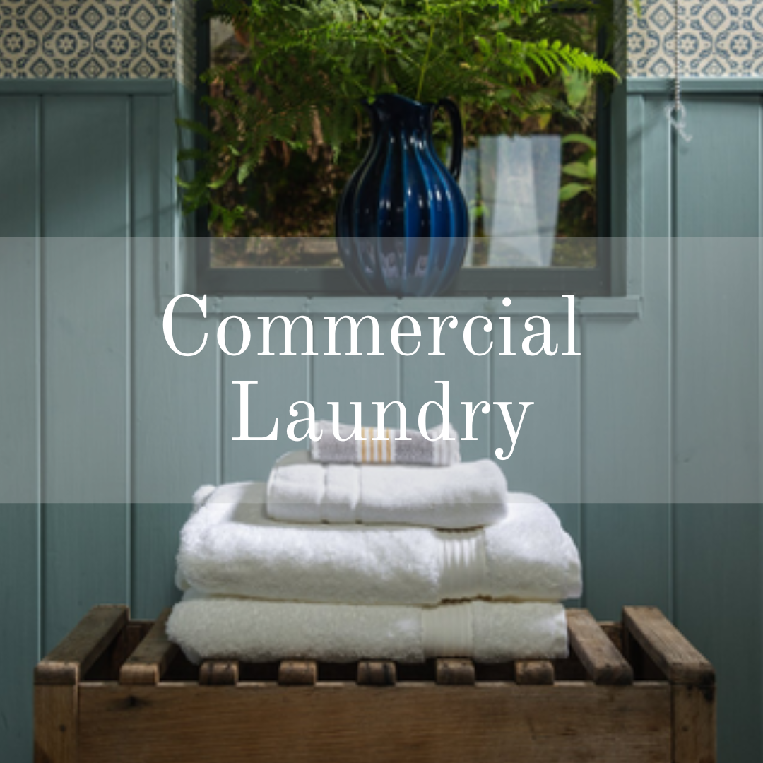 commercial laundry, cotswold tiger laundry - pile of white towels with green painted background