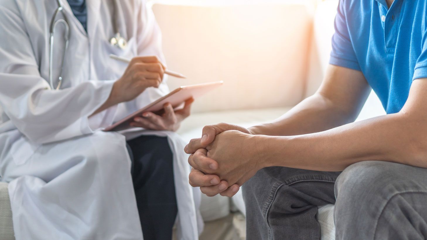 A Doctor is Talking to a Patient Who is Sitting on a Couch — Northern Beaches GP Superclinic in Deeragun, QLD