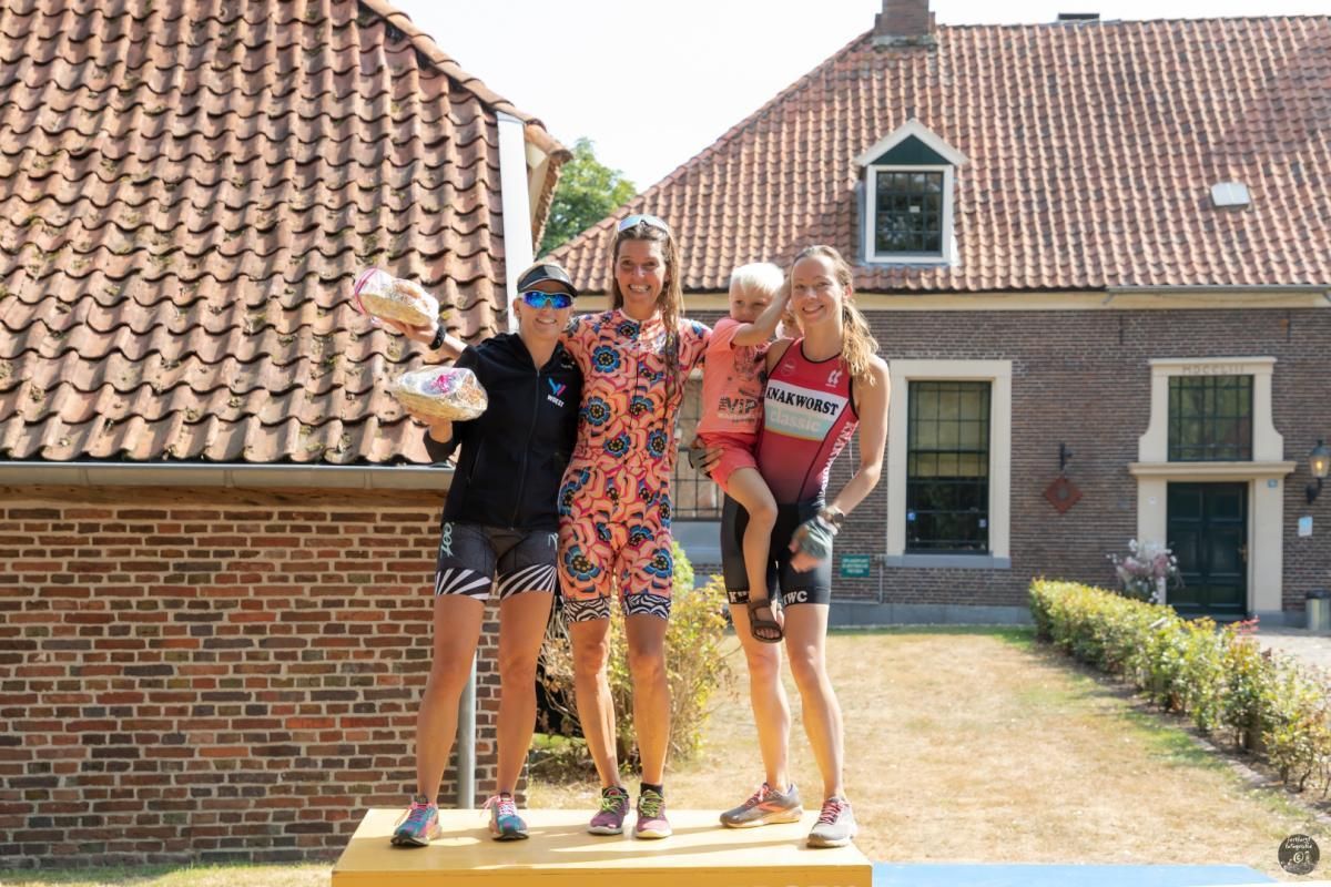 Een groep mensen die op een podium voor een bakstenen gebouw staat.