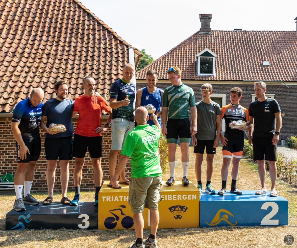 Een groep mannen staat op een podium met het cijfer 2 erop.