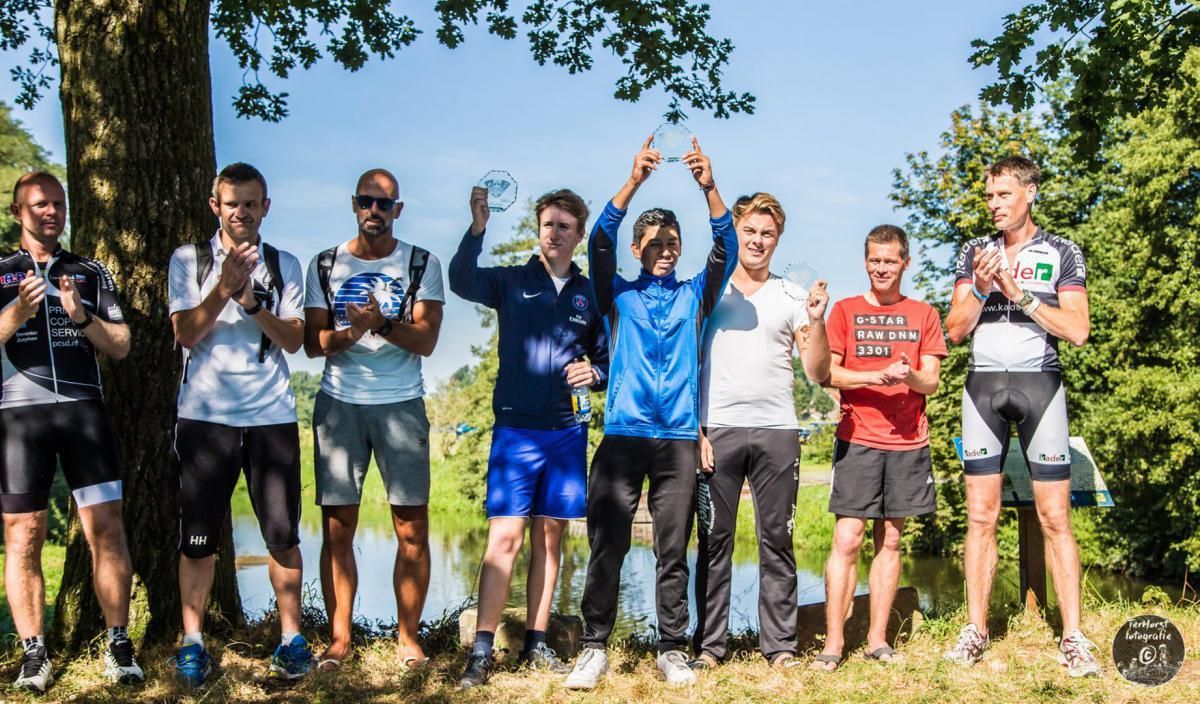 Een groep jonge mannen staat naast elkaar in een veld.