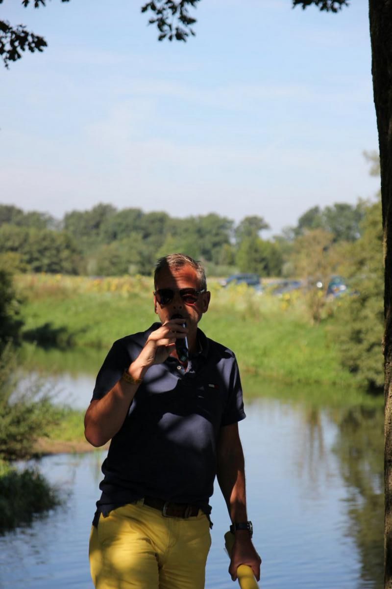 Een man maakt met een camera een foto van een rivier.