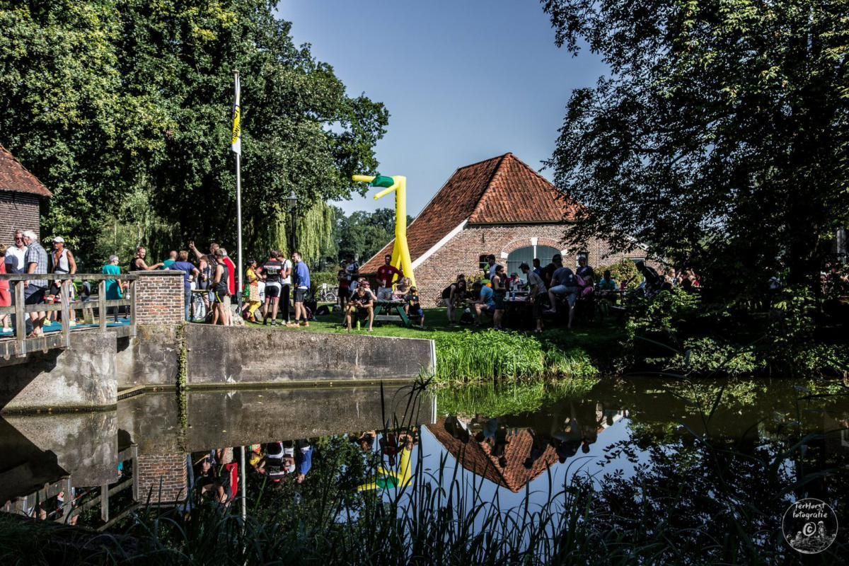 Een groep mensen staat op een brug over een watermassa.