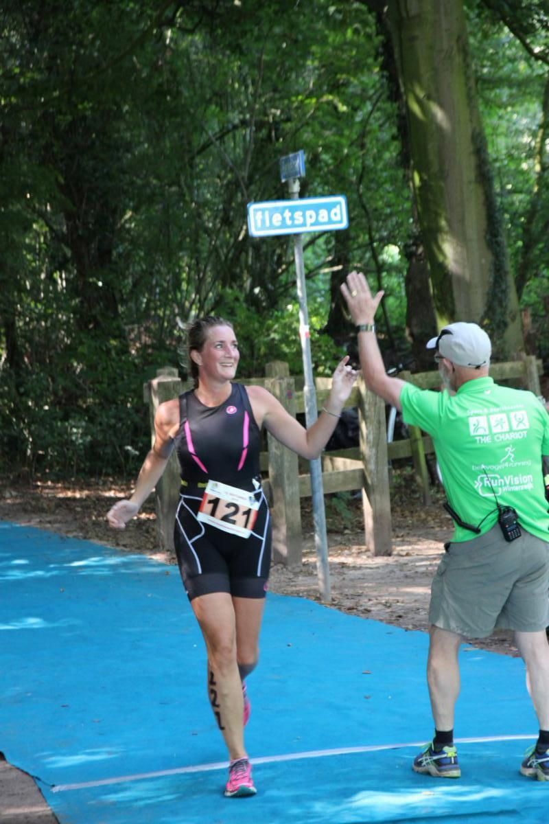 Een man in een groen shirt geeft een vrouw een high five