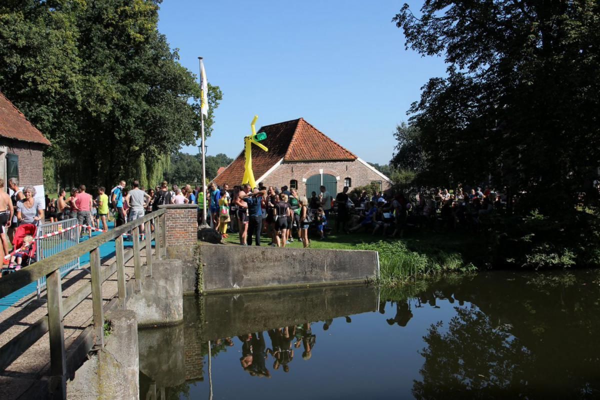 Een groep mensen staat op een brug over een watermassa.