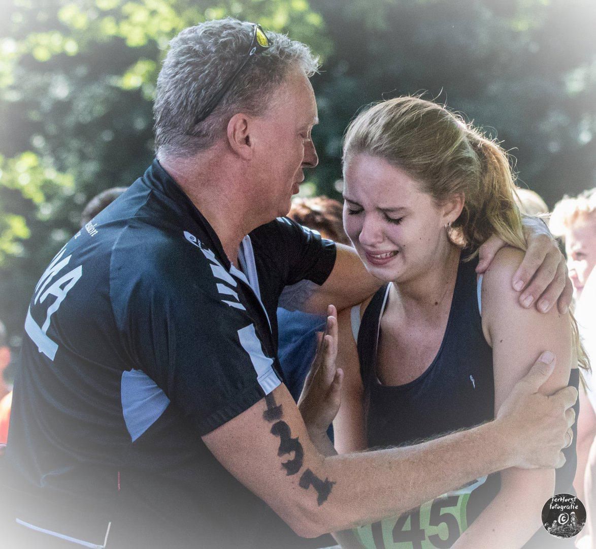 Een man omhelst een vrouw met het nummer 45 op haar arm