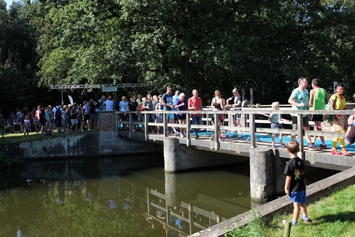 Een groep mensen staat op een brug over een watermassa.