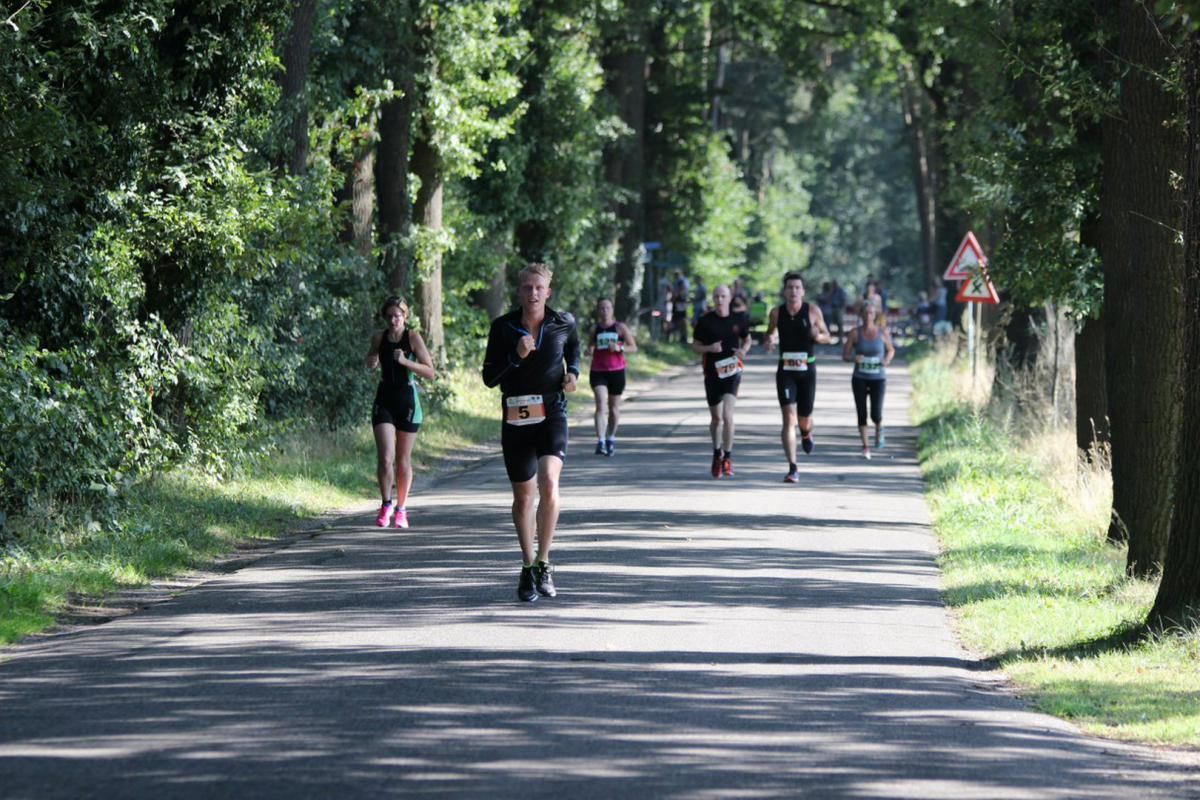 Een groep mensen rent over de weg.