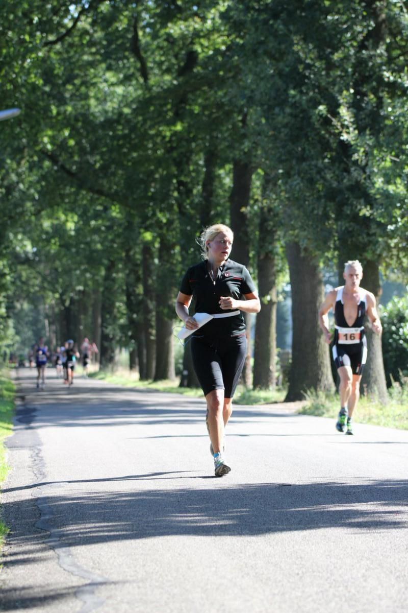 Een groep mensen rent over een weg.