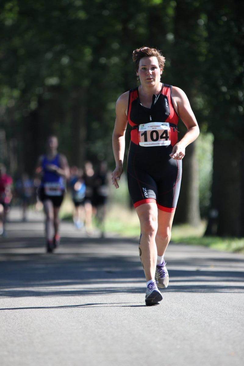 Een vrouw rent met het nummer 104 op haar shirt