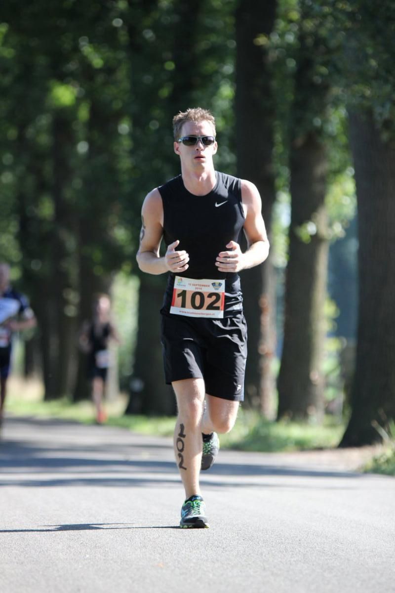 Een man rent mee in een race met het nummer 102 op zijn startnummer