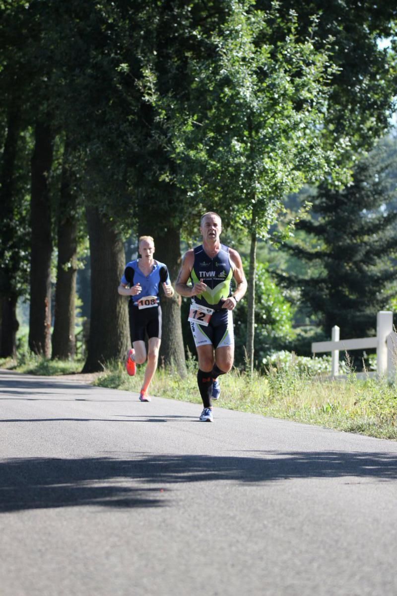 Een man en een vrouw rennen over de weg.
