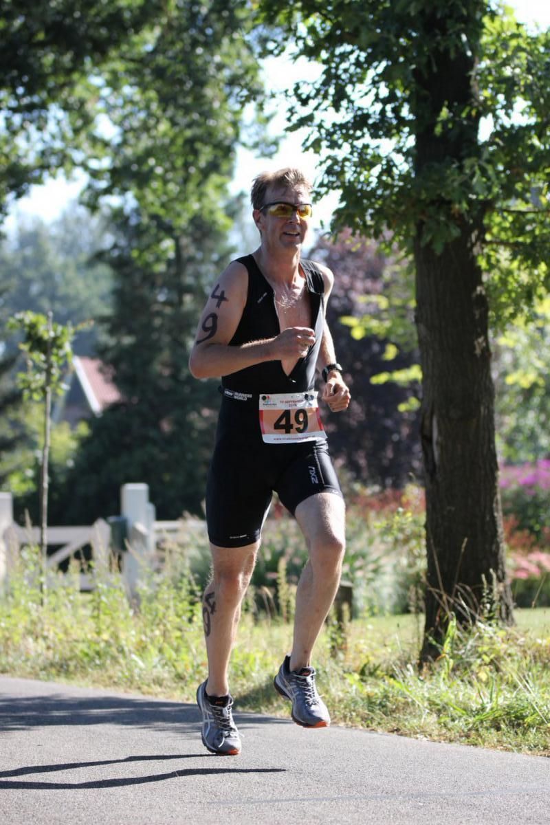 Een man rent over de weg met een startnummer 49 om.