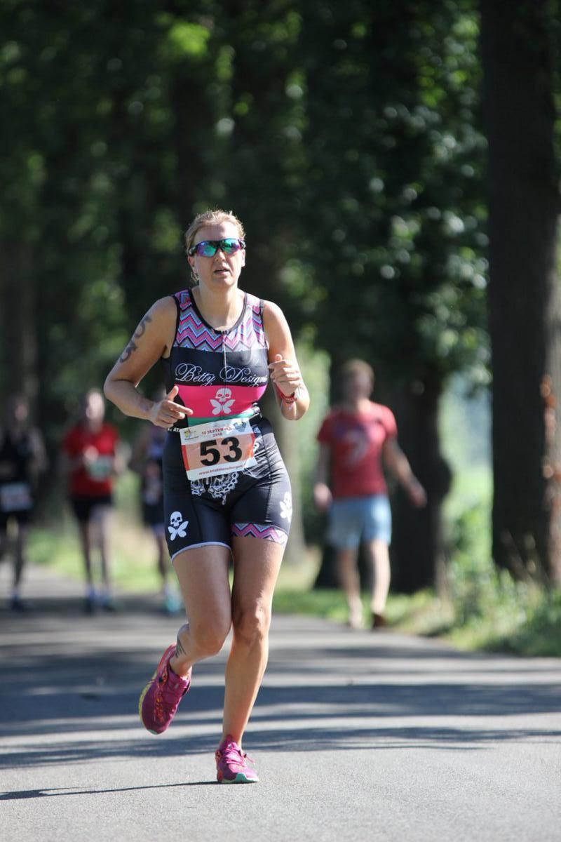 Een vrouw rent een marathon op de weg.