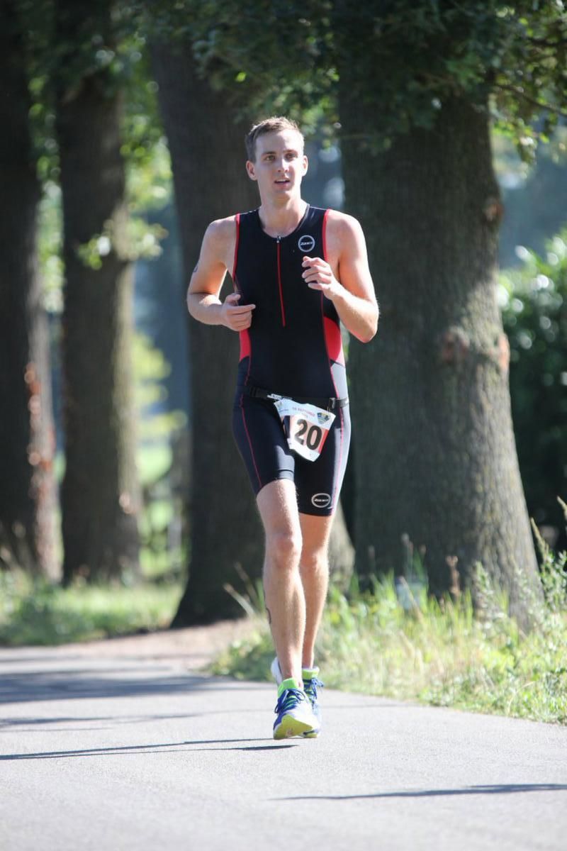 Een man rent over de weg met het nummer 20 op zijn startnummer.