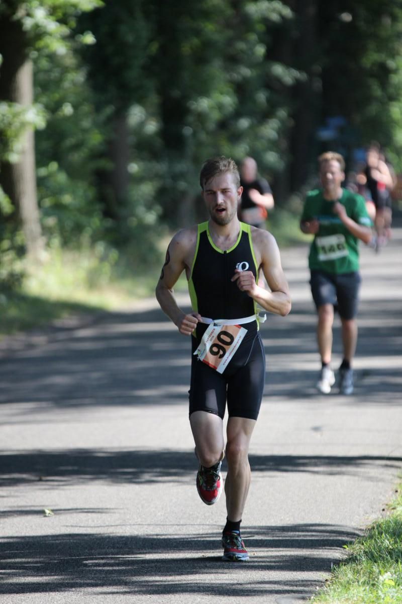 Een man met rugnummer 80 rent over de weg.
